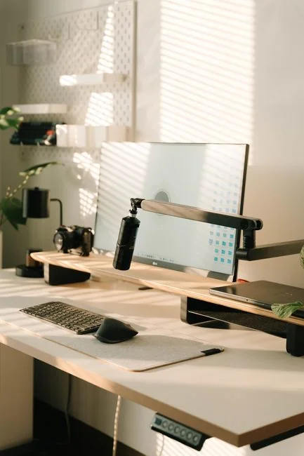 creative Vue en plongée d’un bureau de travail élégant avec deux écrans, un clavier, une souris et des accessoires modernes.